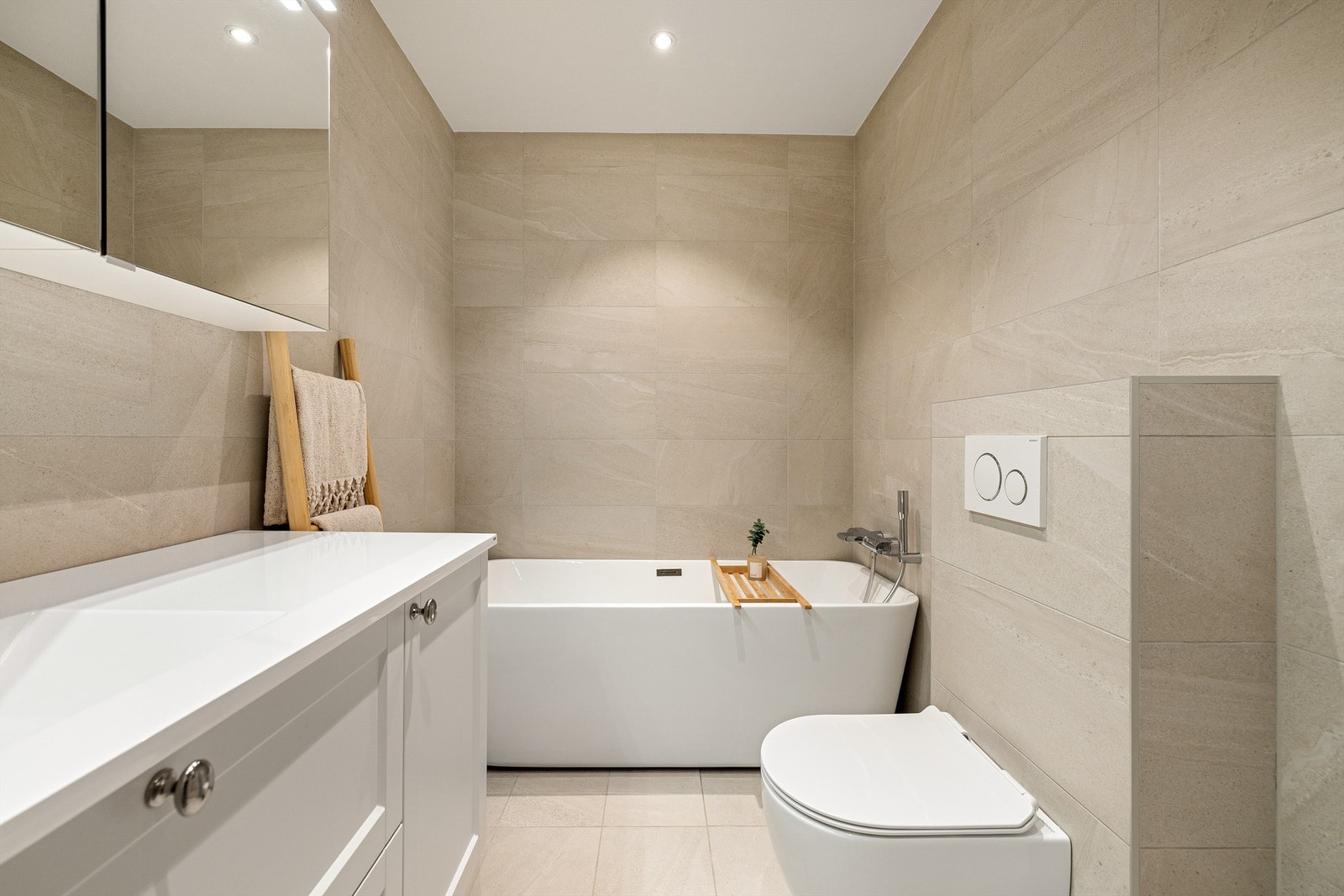 Delikat bad med varme, og gjennomførte fargetoner som skaper en rolig atmosfære. Armatur på badekar fra Grohe. Galleribilde