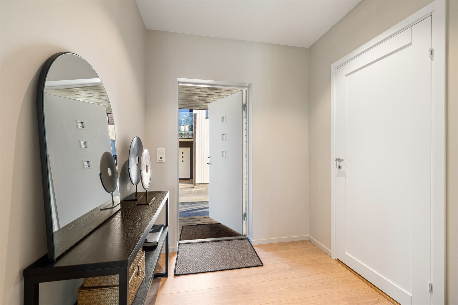 Entré med rolig fargeskala, og lysinnslipp fra døren som skaper et imøtekommende førsteinntrykk. Galleribilde