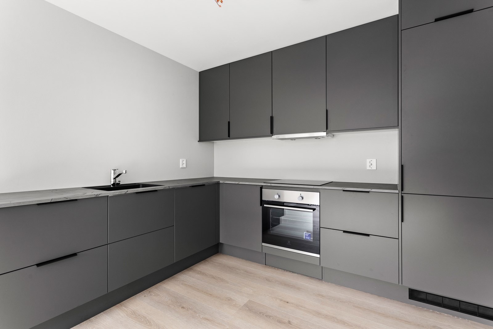 Eit stilreint og delikat kjøkken med praktiske overskap til himling. Galleribilde