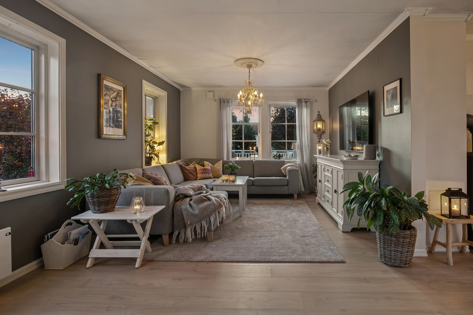 Romslig og gjennomlys stue med vinduer på flere sider som slipper inn rikelig med dagslys. Galleribilde