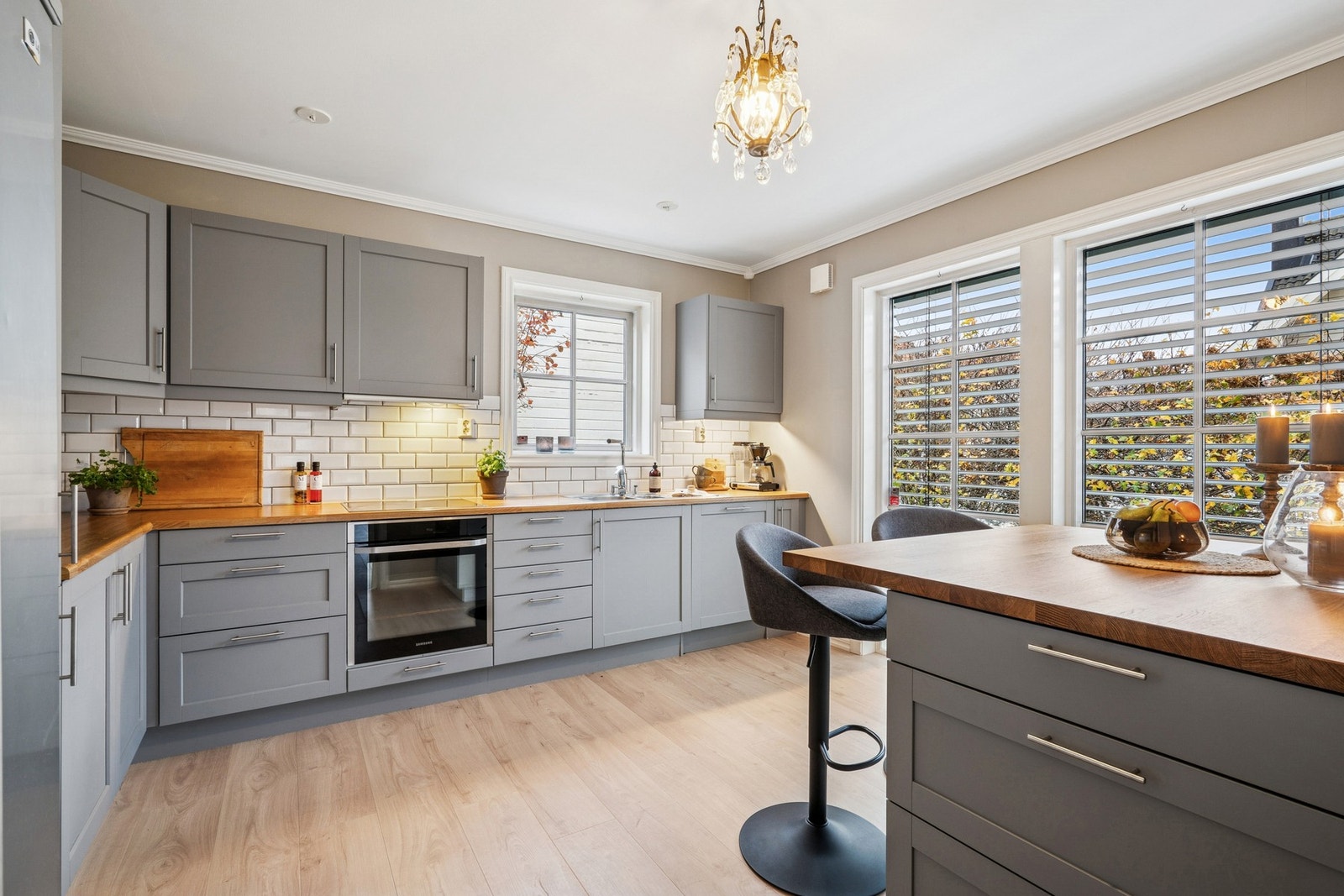 Innredningen i grå toner kombineres med benkeplate i tre og klassisk flislagt vegg over benk. Galleribilde