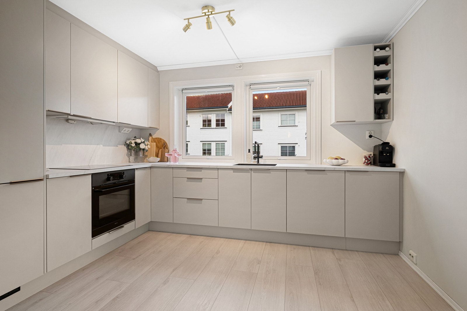 Lyst og lekkert kjøkken med integrerte hvitevarer og godt med skap- og benkeplass. Galleribilde