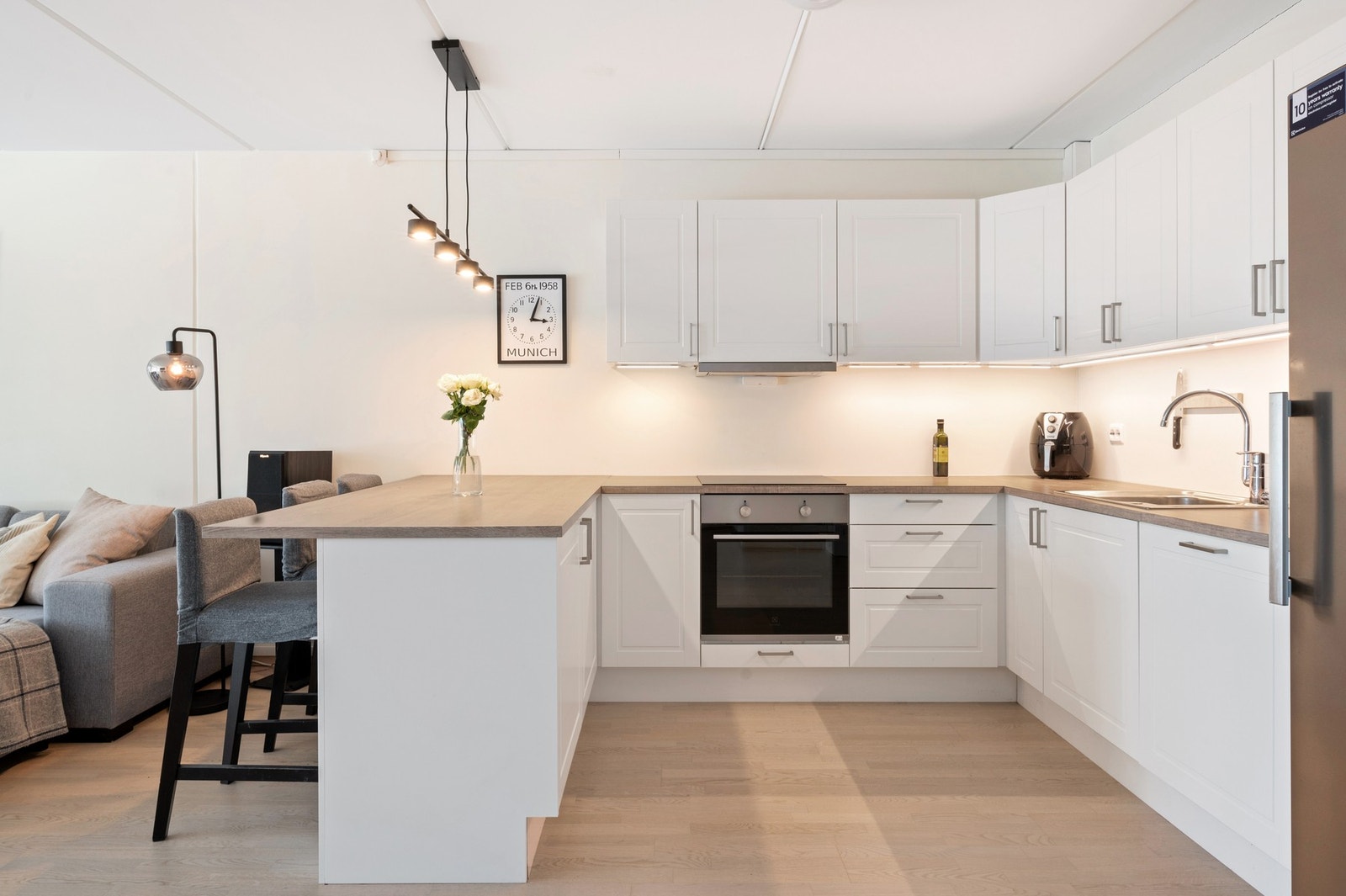 Kjøkken med integrerte hvitevarer og barløsning på hjørnet Galleribilde