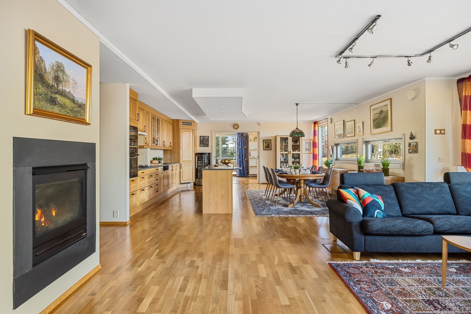 Du kommer videre inn i en stor og lys åpen stue- og kjøkkenløsning. Galleribilde