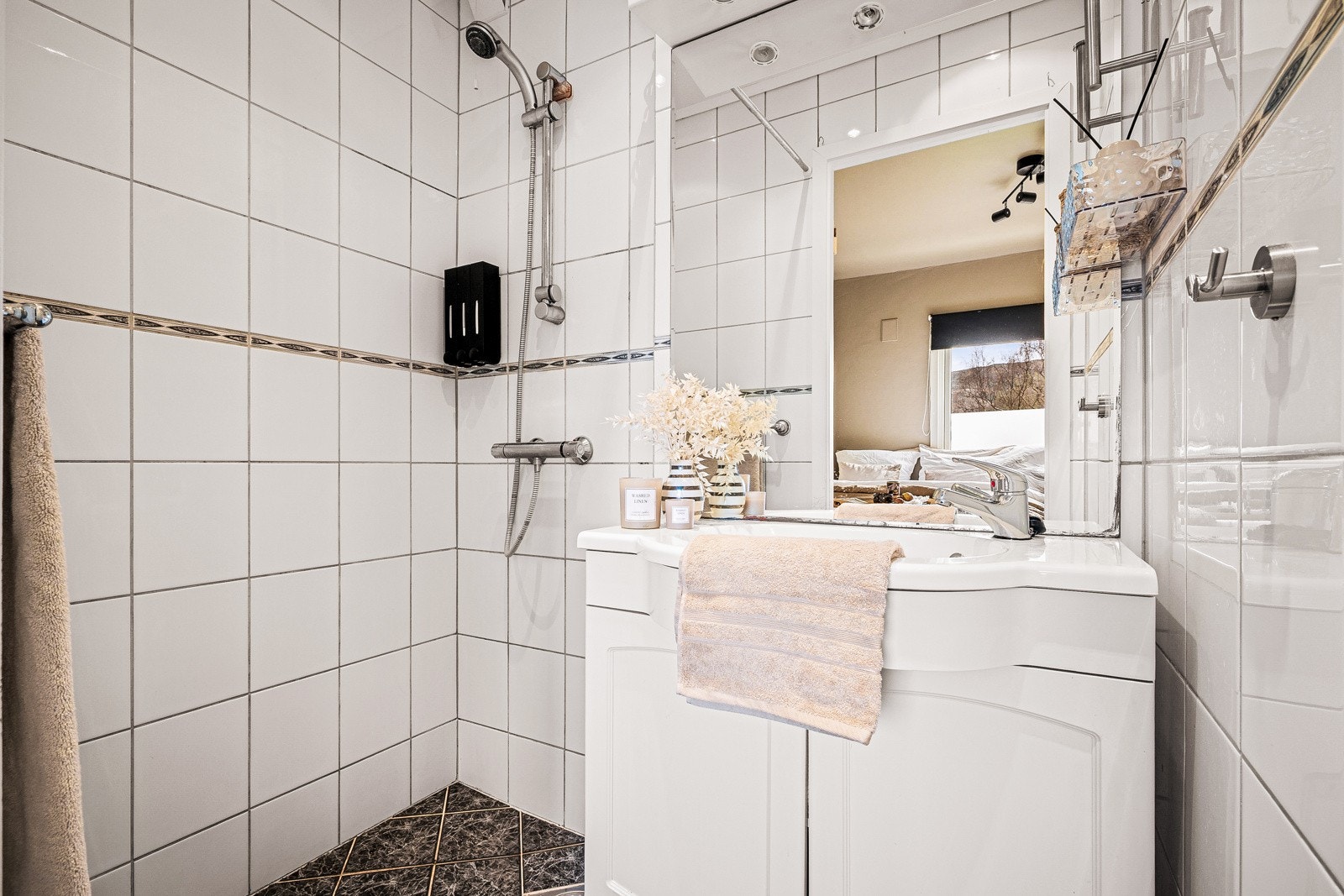 - Badet er helfliset og innredet med dusj med forheng, servant med møblement, speil og belysning - Galleribilde