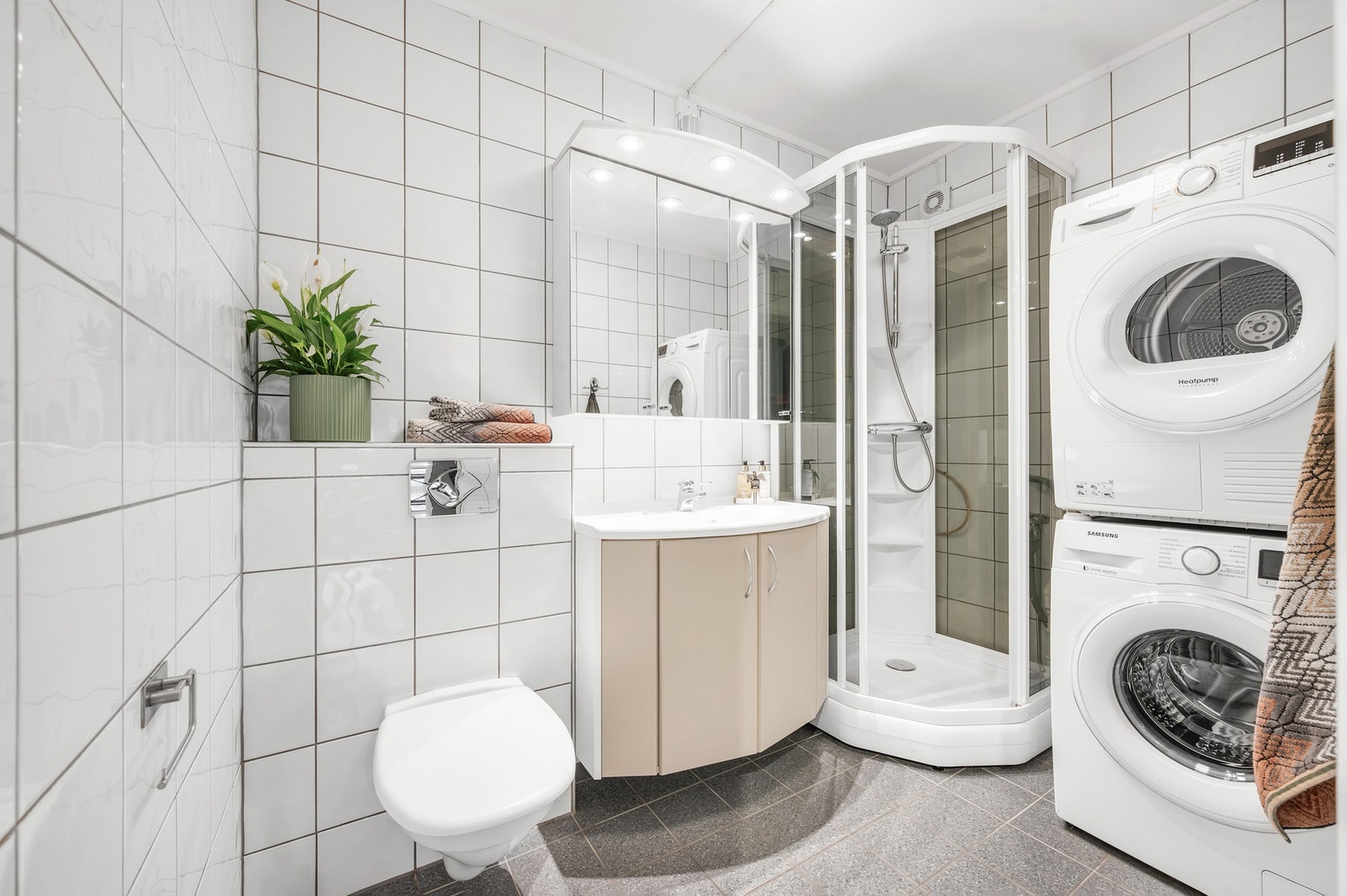 - Pent og moderne bad med fliser på vegger og gulv og opplegg for vaskemaskin. Galleribilde