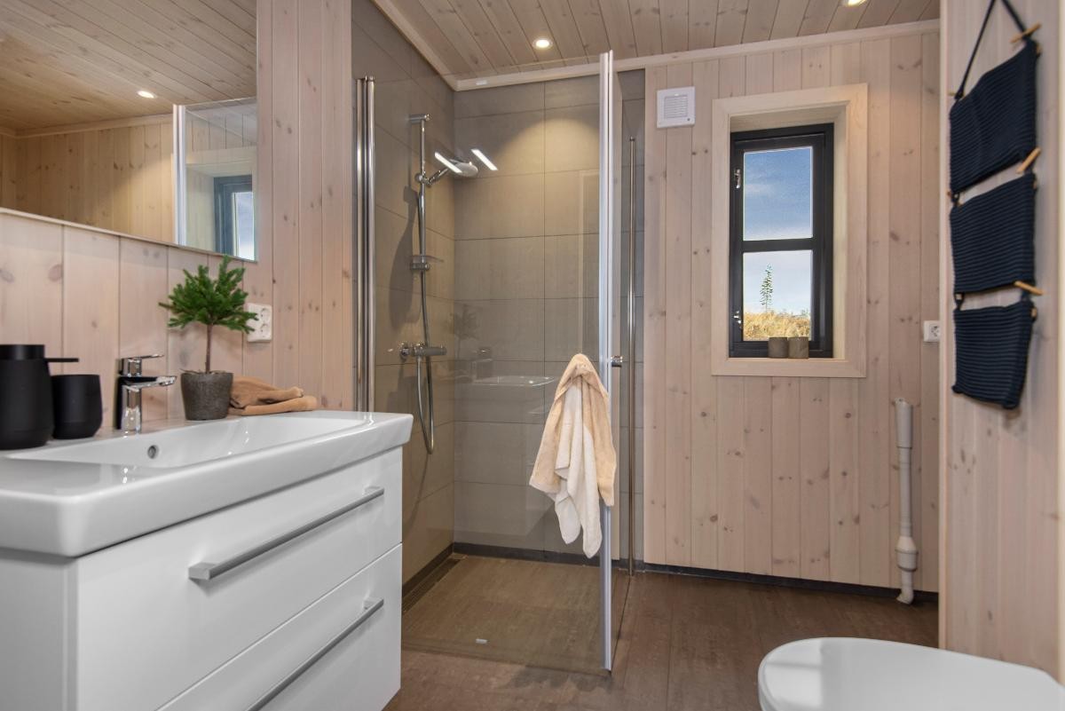 Vegger og tak beiset i fargen Himmelgrå. Standard fliser 30x60. Galleribilde