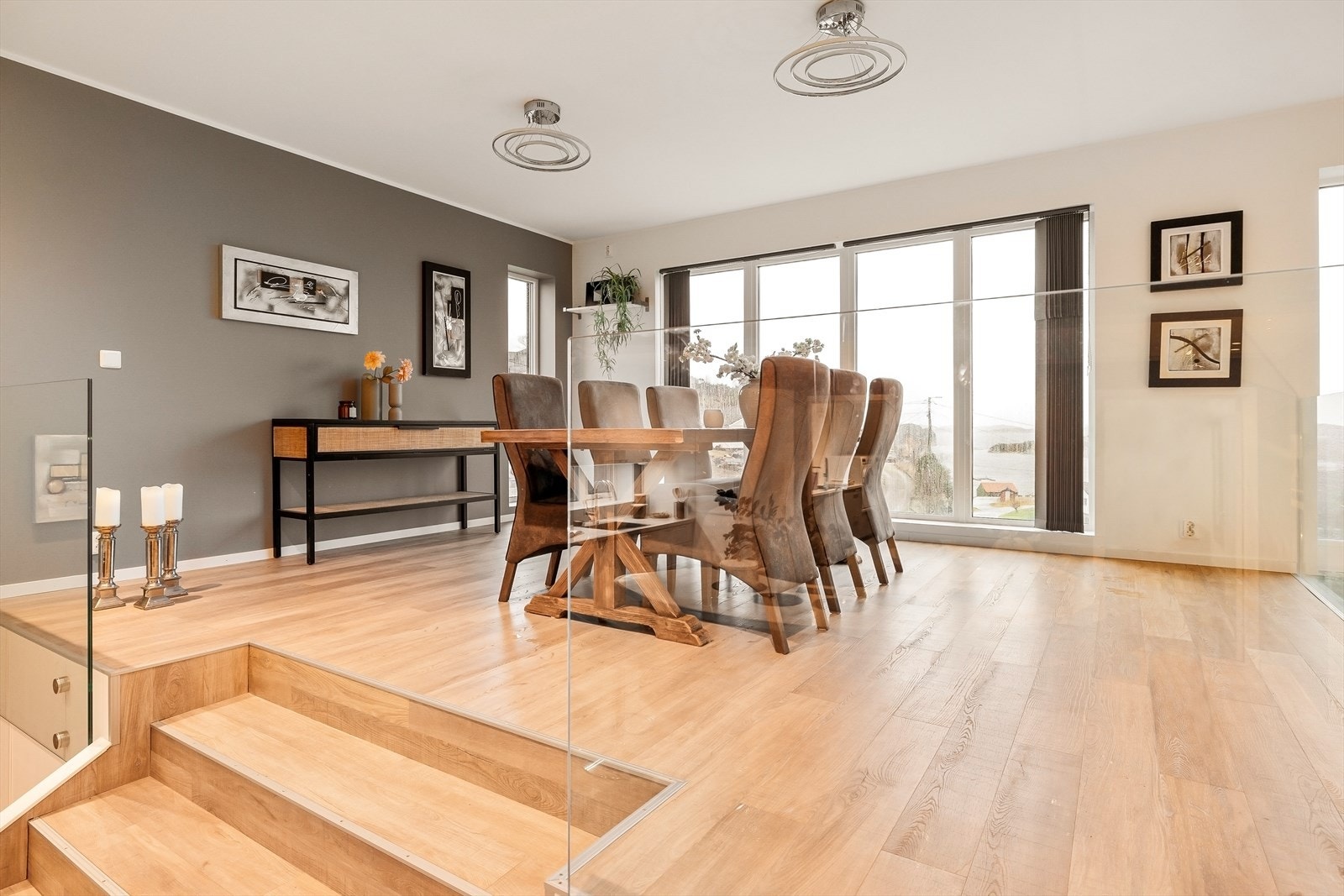 Det forhøyede spiseområdet skaper en naturlig sone for hyggelige middager og sosiale sammenkomster; stilrent, innbydende, og perfekt integrert i boligens moderne uttrykk. Galleribilde