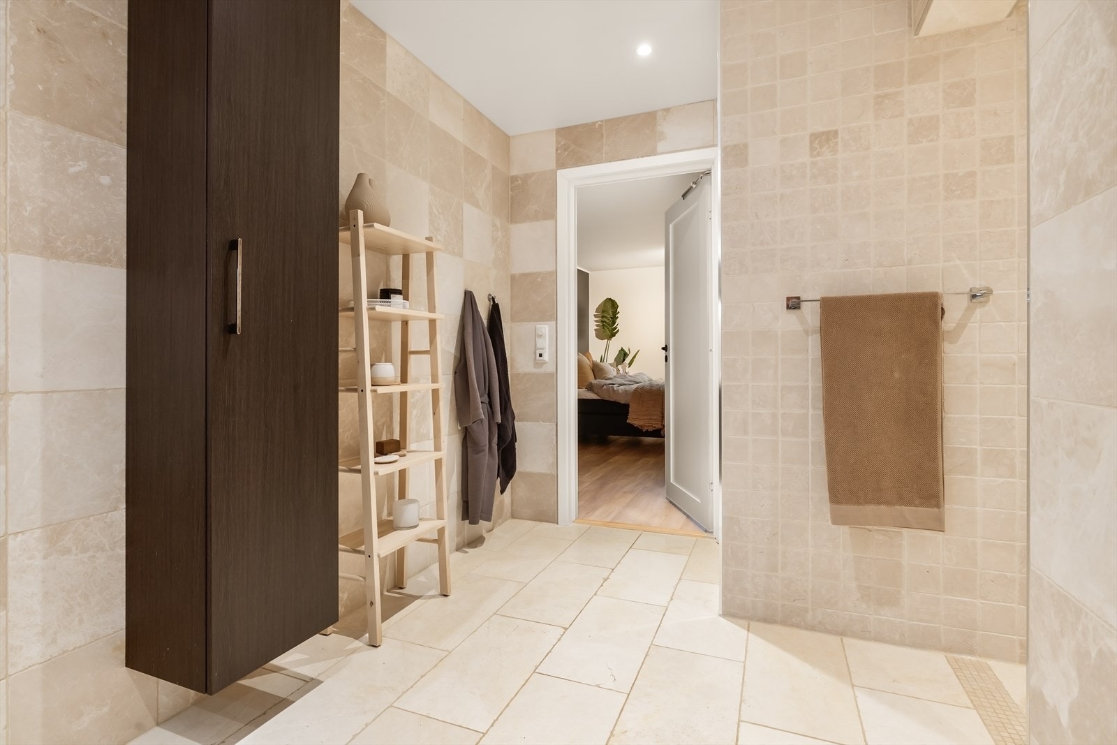 Et nydelig, helfliset bad med varme fargetoner og sterke kontraster mellom innredning og overflater. Galleribilde