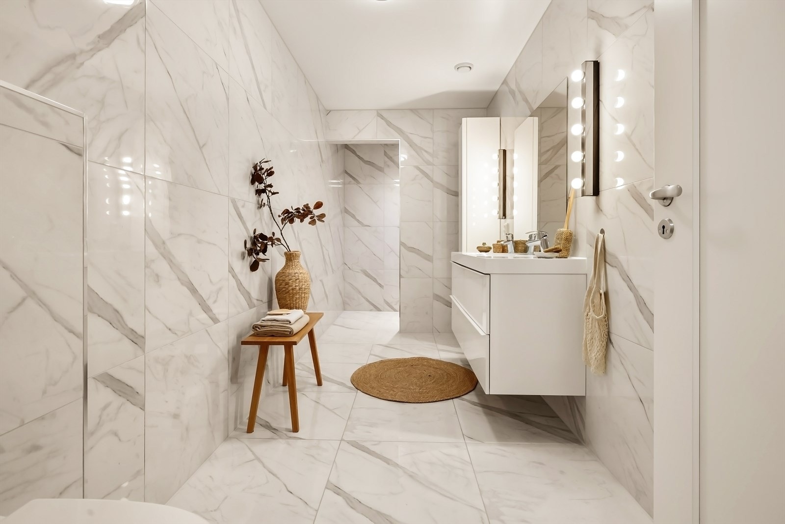 Hoveddelens andre bad i lekre, hvite fliser med marmortrykk på vegg og gulv. Det er også varme i gulv. Galleribilde