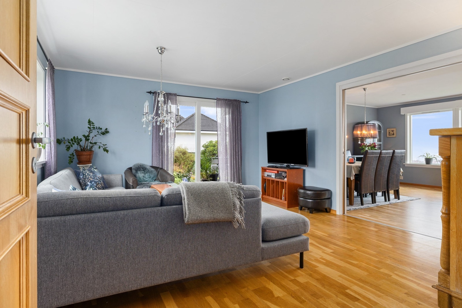 Lys stue med utgang mot spisestue og store vindusflater. Galleribilde