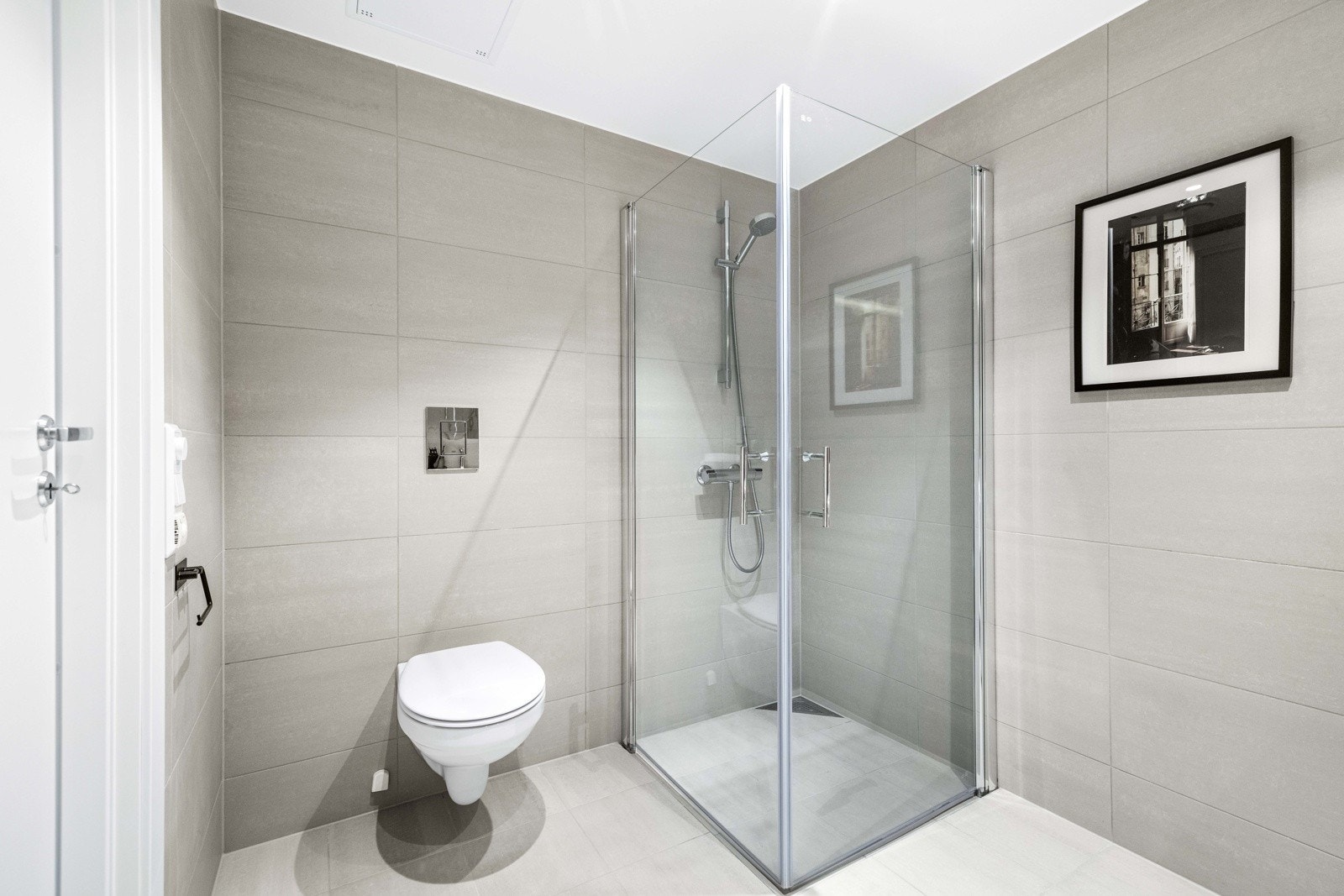 Badet har lyse fliser på vegger og gulv, gulvvarme og downlights. Galleribilde