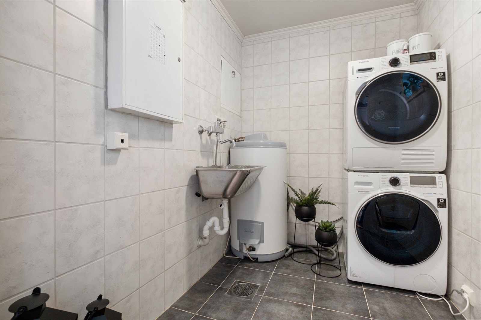 Vaskerom. Veggene har fliser. Taket har himlingsplater. Gulvet er flislagt. Rommet har elektriske varmekabler. Rommet er innredet med utslagsvask/stålkum, sikringsskap, vannfordelerskap, opplegg for vaskemaskin og varmtvannsbereder. Galleribilde
