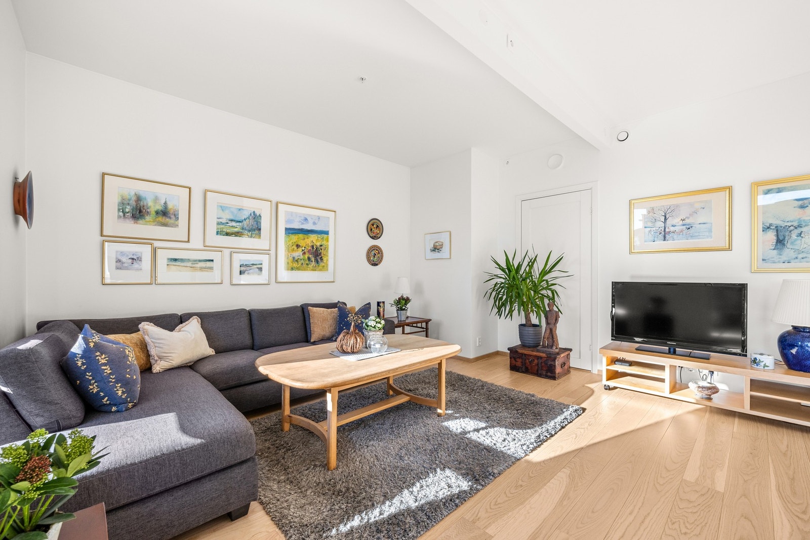 Her har du en lys og luftig stue med store vindusflater som skaper en innbydende atmosfære Galleribilde