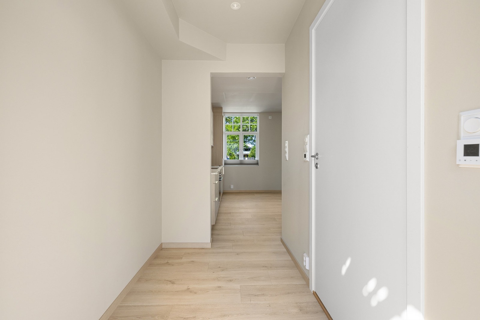 Entreen har i likhet med badet både gulvvarme og innfelte spotter som kan dimmes. Åpen forbindelse til stuen gir siktlinje til parken. Galleribilde