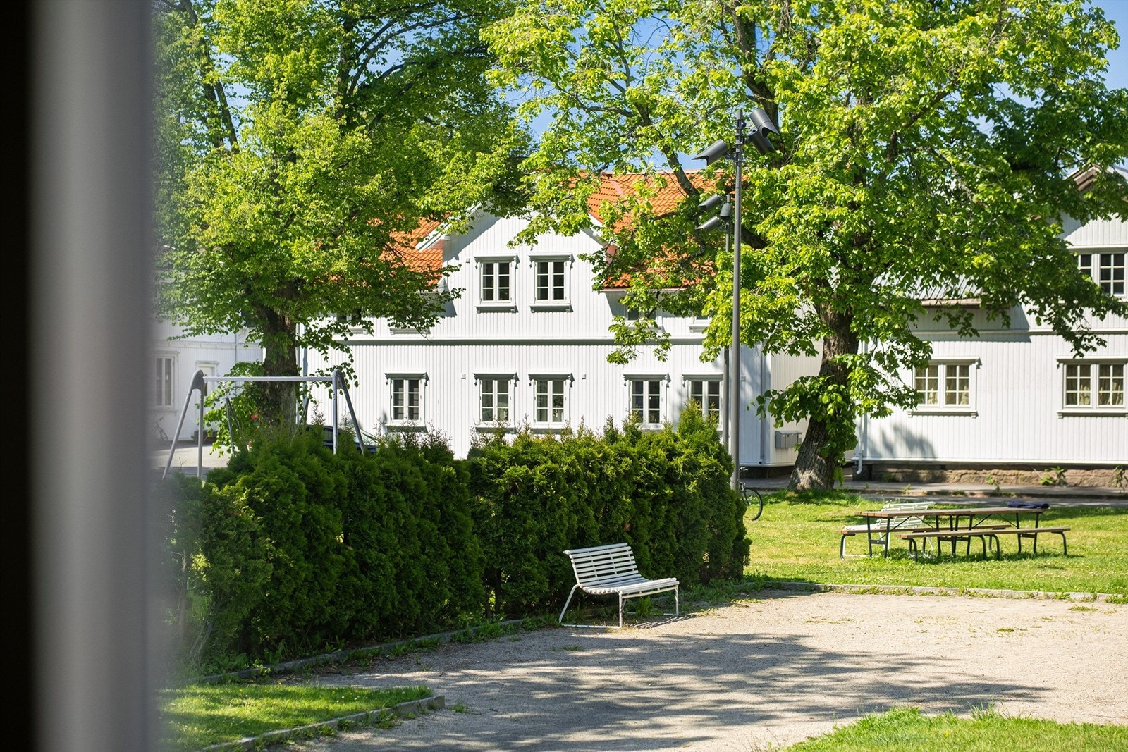 Gjennom vinduene ser du rett ut mot parken som utgjør et frodig og vakkert bakteppe til stuen. Galleribilde