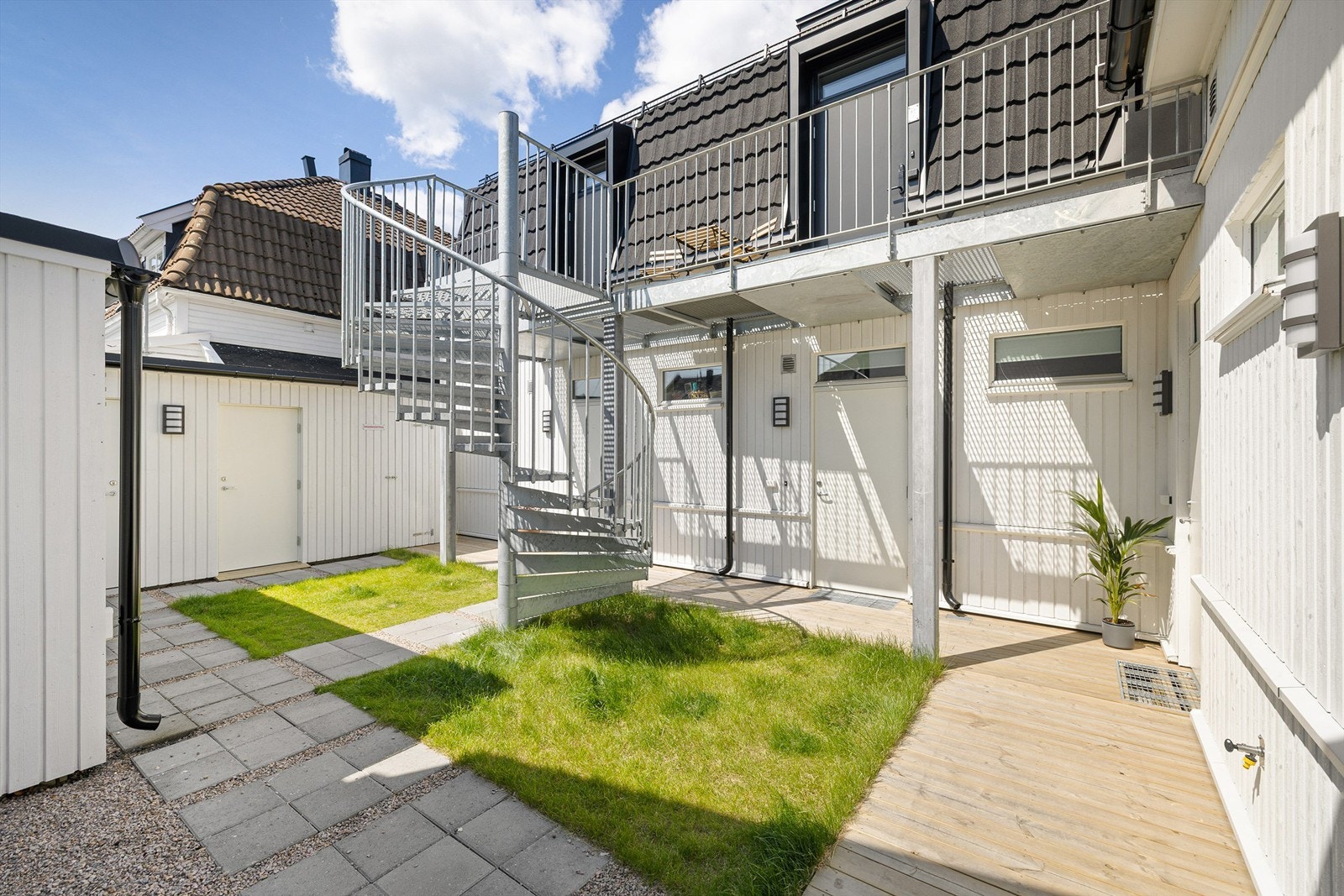 På plattingen foran inngangspartiet i sameiets avlukkede gårdsrom er det sommerstid sol store deler av dagen. Galleribilde