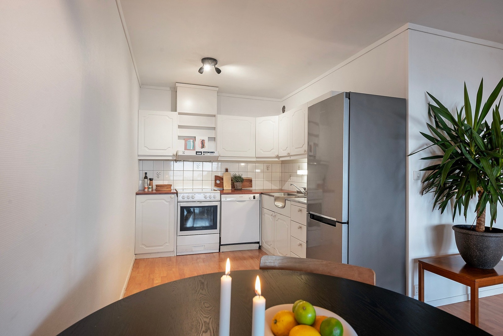 Kjøkkenet har eldre, profilerte fronter i klassisk stil. Benkeplaten er i laminat med heldekkende oppvaskbenk i stål Galleribilde