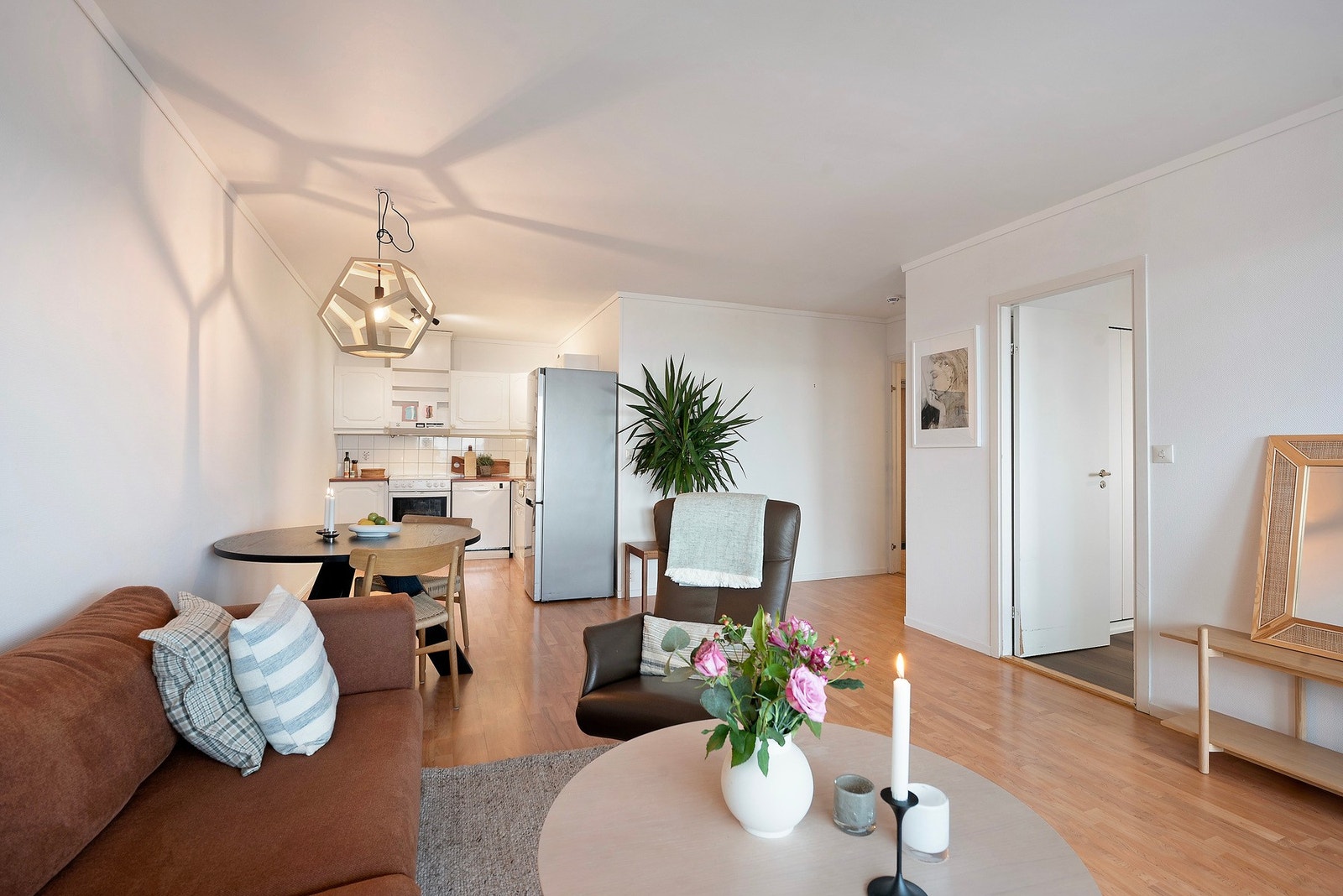 God planløsning med åpen løsning mellom stue og kjøkken - et sosialt og luftig oppholdsrom som innbyr til trivsel Galleribilde