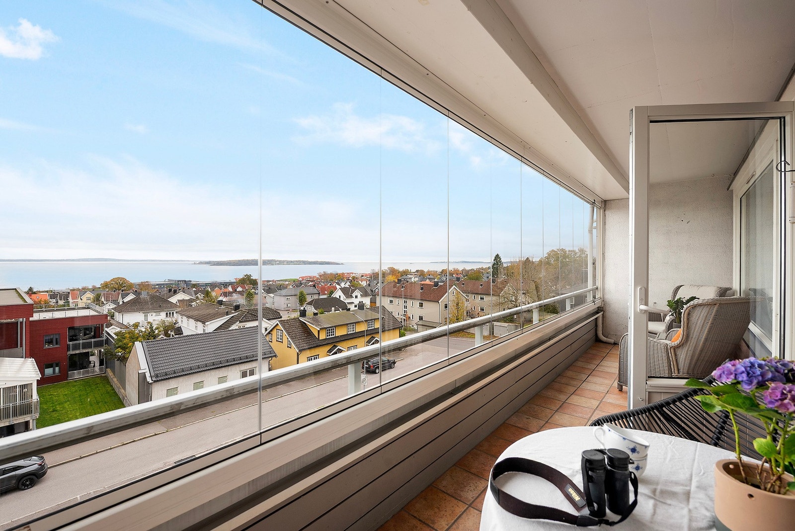 Balkongen er innglasset med skyvevinduer og har støpt gulv med fliser Galleribilde