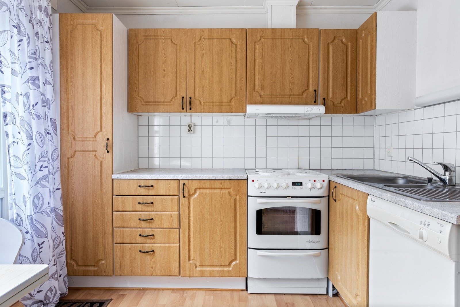 Innredning med profilerte fronter, laminert benkeplate og fliser mellom benk og overskap. Galleribilde
