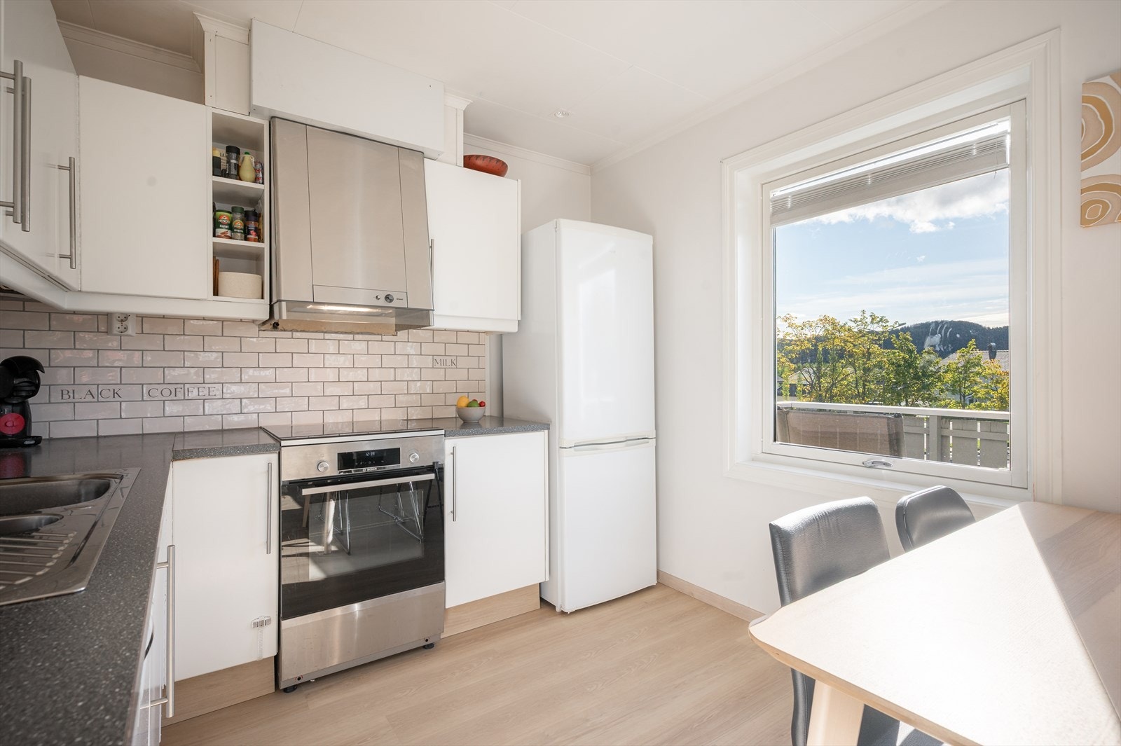 Kjøkkenet har en hvit, profilert innredning som har godt med skap- og benkeplass for god arbeidsflyt. Galleribilde