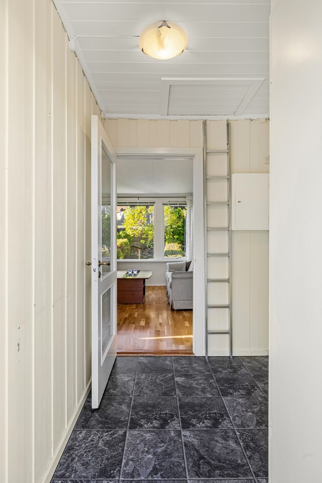 I entreen er det laminatgulv og malt panel på veggene. Luke til koffertloft. Galleribilde