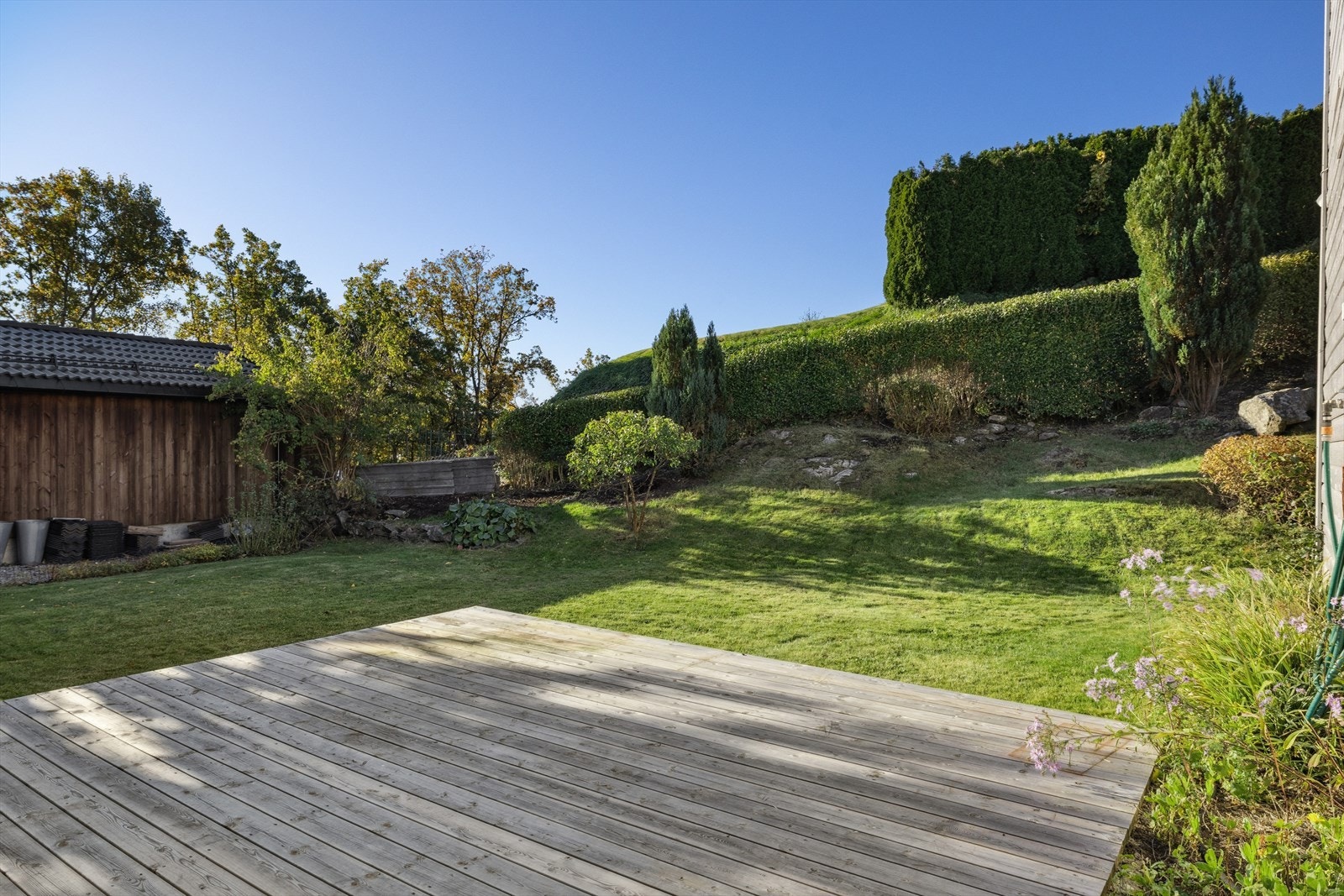 Hagen er pent opparbeidet med terrasseplatting , plen og beplantning. Galleribilde