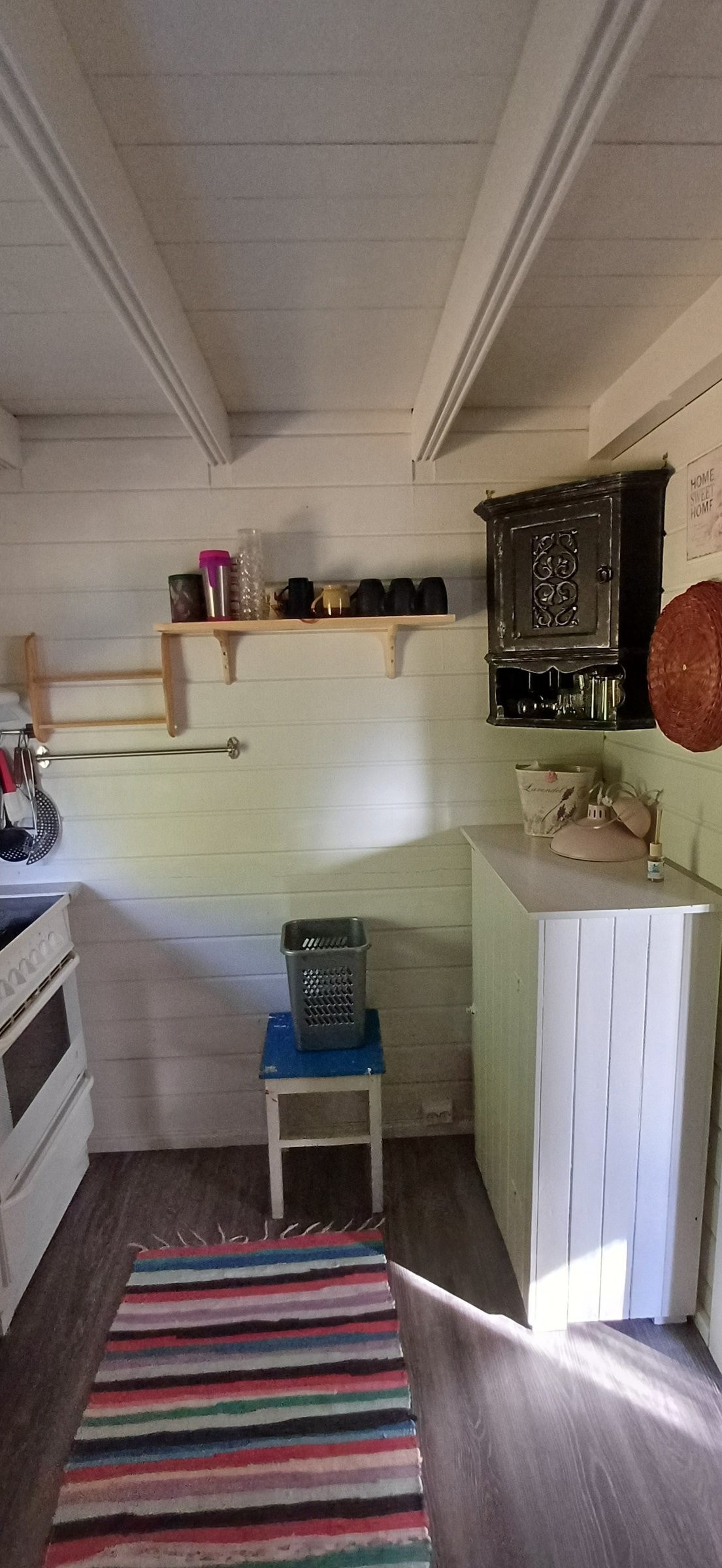 Del av kjøkken med hyller og skap. Kråskap inneholder glass av diverse slag, gulv skap inneholder en del tallerkener etc Galleribilde