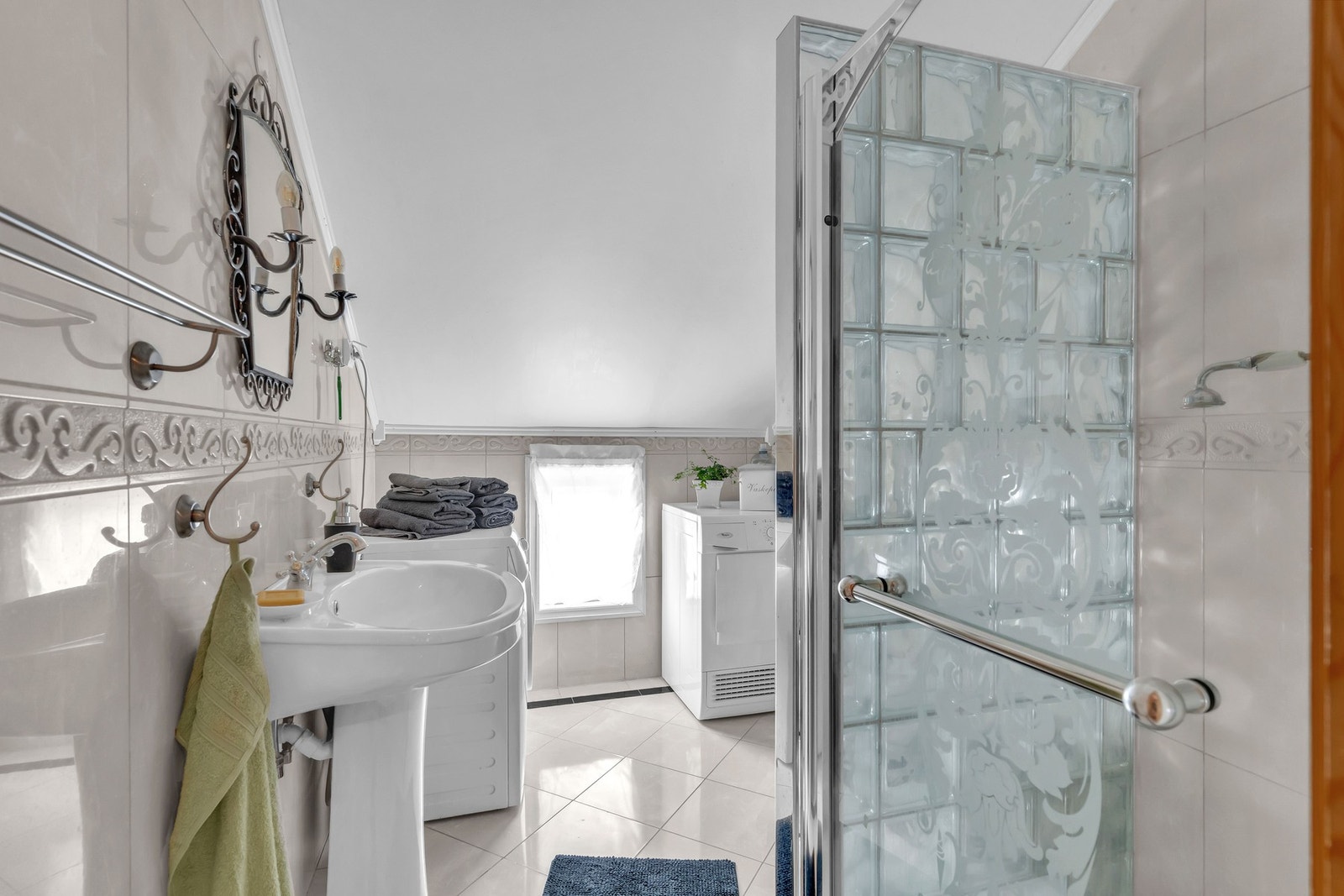 Boligens andre bad har flislagte overflater, noe skråhimling og gulvvarme. Galleribilde