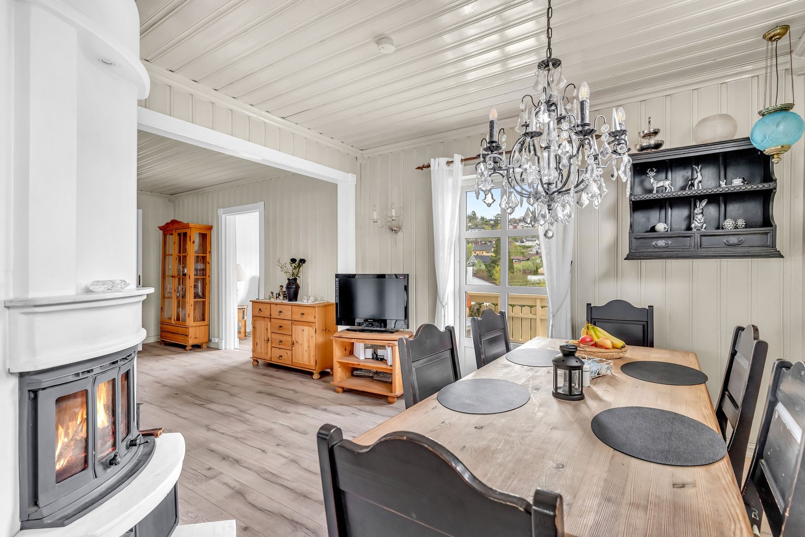 Kjøkkenet ligger tilknyttet en spisestue med peis og byr på rikelig med skap- og benkeplass i kremhvit innredning. Galleribilde