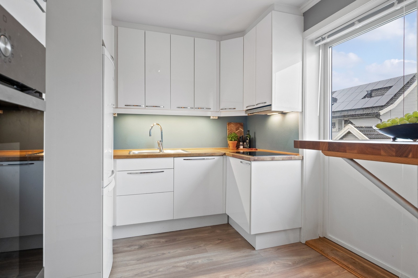 Pent kjøkken med innredning fra 2012 - her er det godt med skap og benkeplass Galleribilde