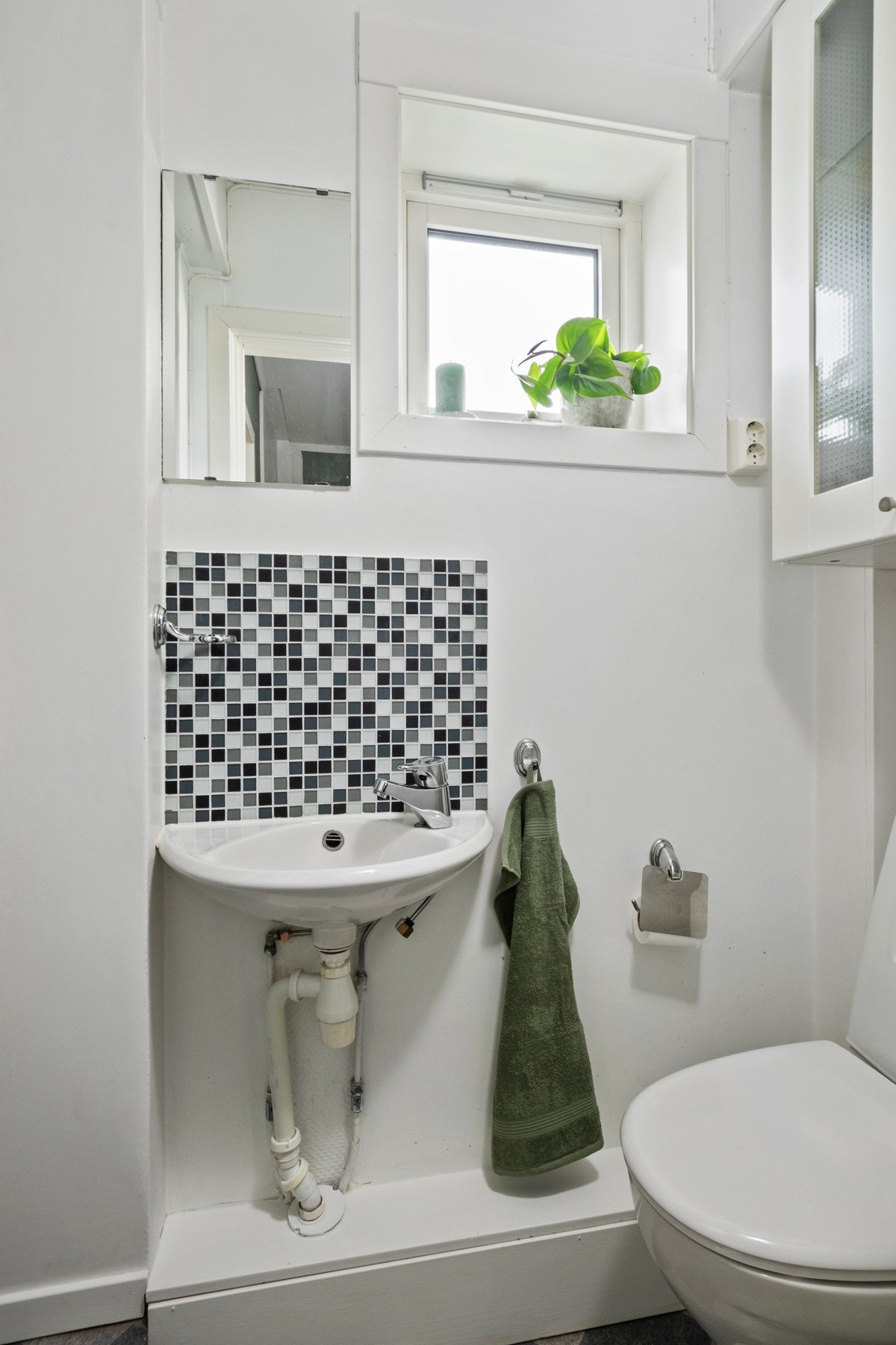 Lite bad utstyrt med toalett, servant og dusjkabinett Galleribilde