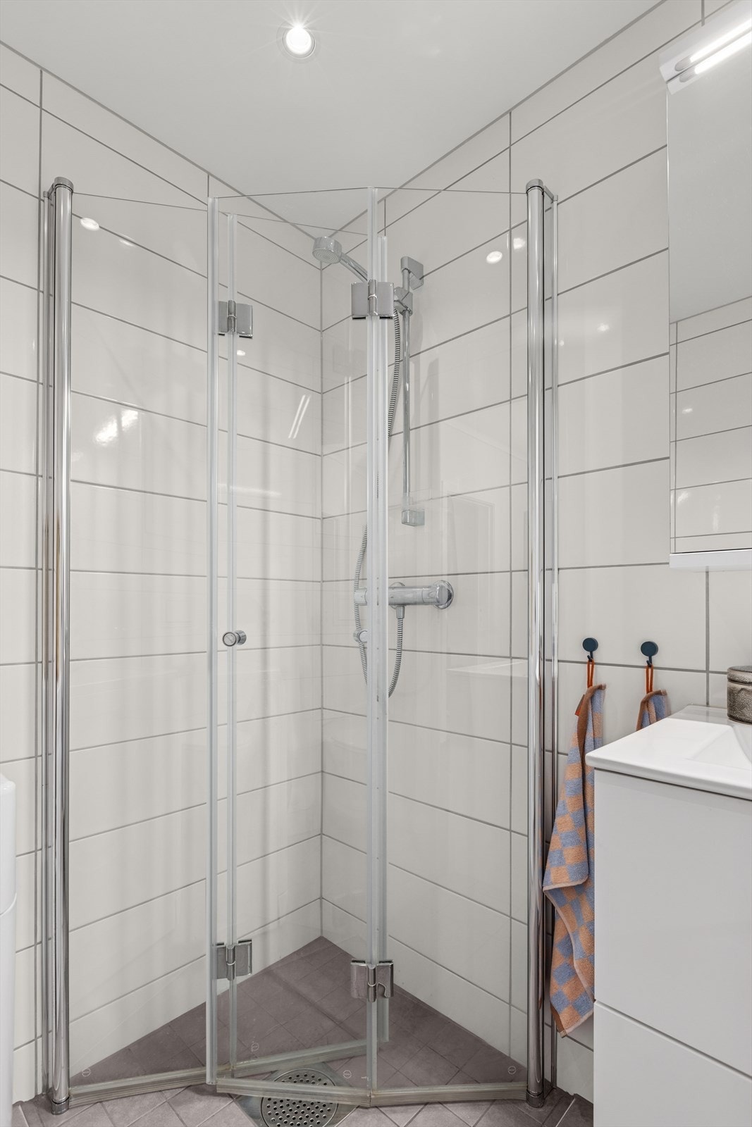 Her finner du dusjhjørne m/innfellbare glassdører, vegghengt toalett, opplegg for vaskemaskin og baderomsinnredning Galleribilde