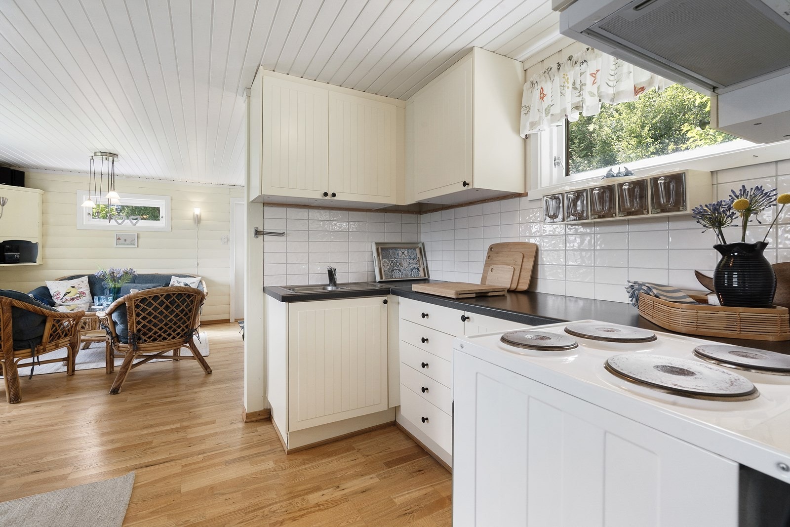 Kjøkken med flislagt vegg mellom overskap, laminert benkeplate og rikelig skapplass for praktisk oppbevaring. Galleribilde