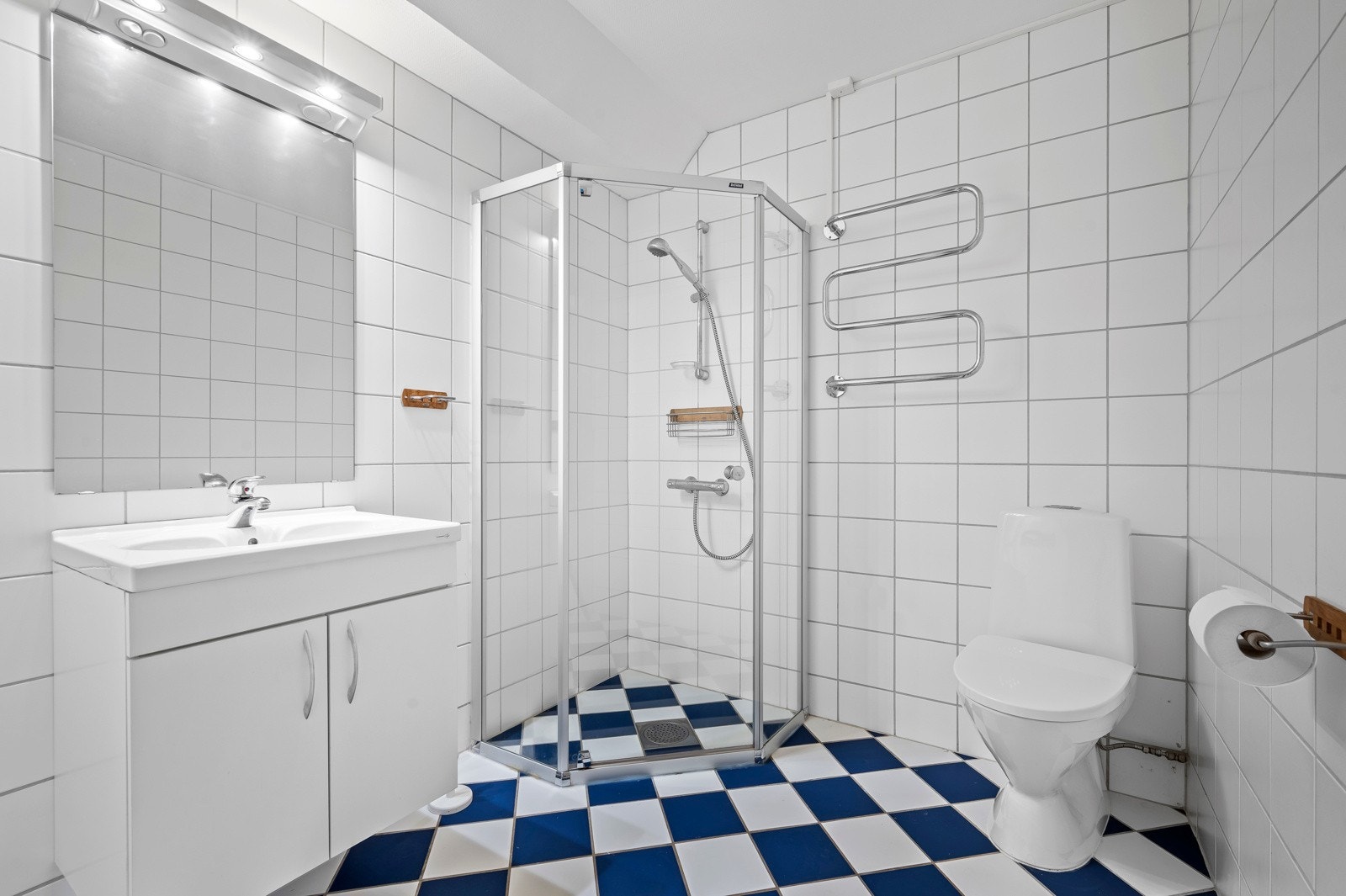 Badet har dusjnisje, toalett, servant og håndklætørker Galleribilde