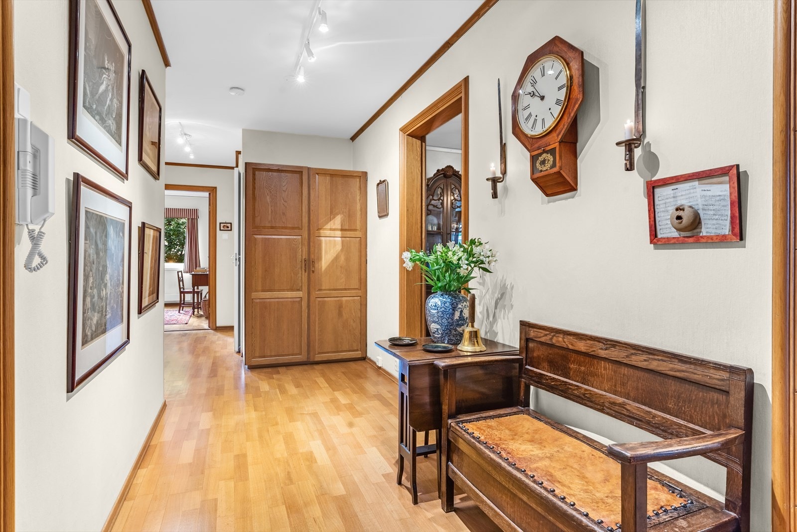 Romslig gang med parkettgulv og plass til skap og diverse møbler Galleribilde