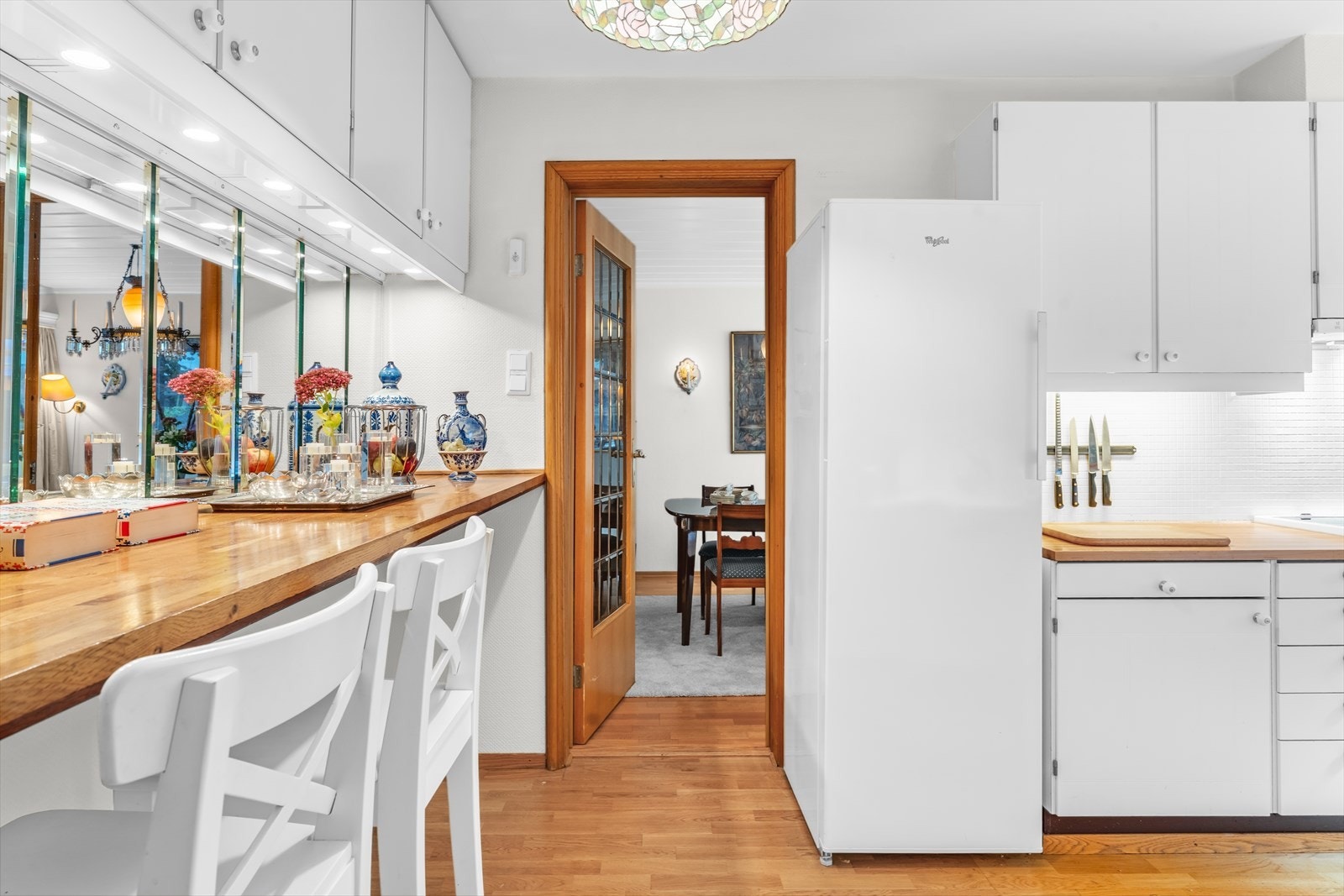 Her er det mye skap -og lagringsplass. Dør med blyinnfattet glass mellom spisestue | kjøkken Galleribilde