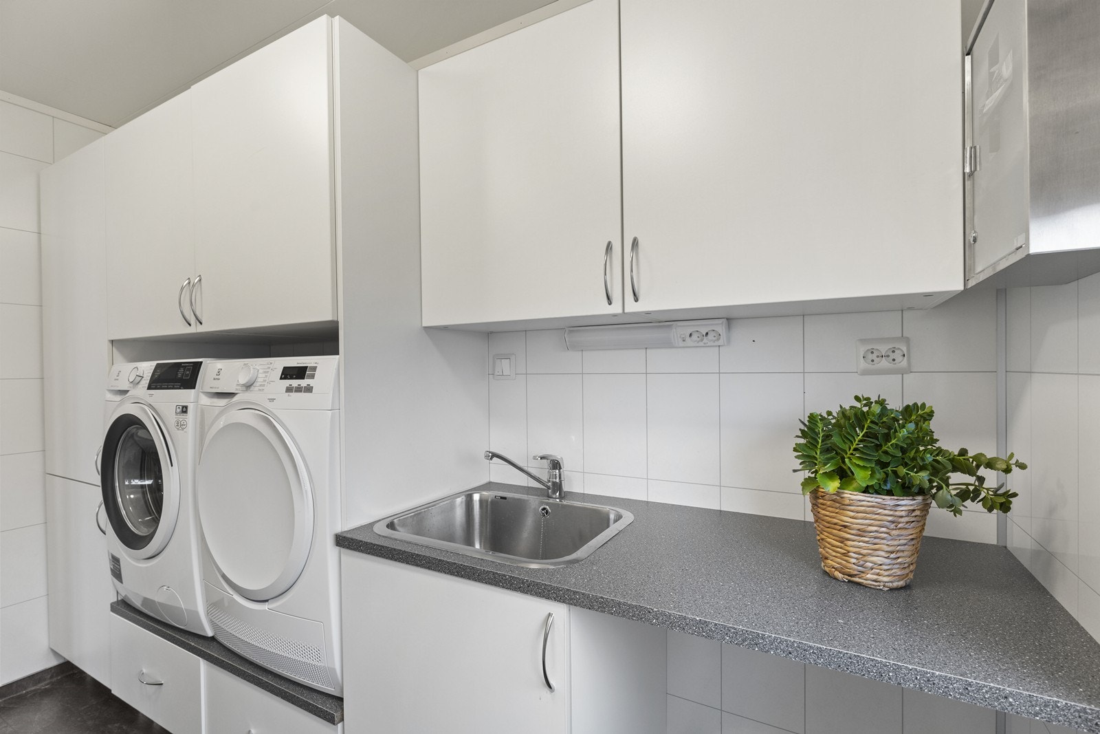 Vaskerom med praktisk innredning, skyllekar, benk og rikelig skapplass. Galleribilde