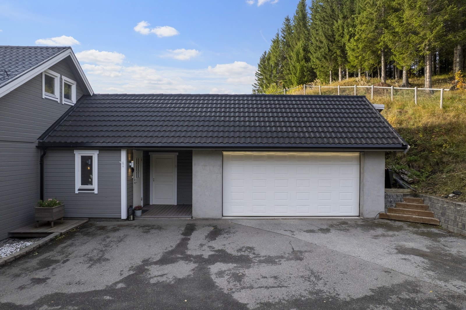 Romslig dobbelgarasje og asfaltert adkomst med biloppstillingsplasser. Galleribilde