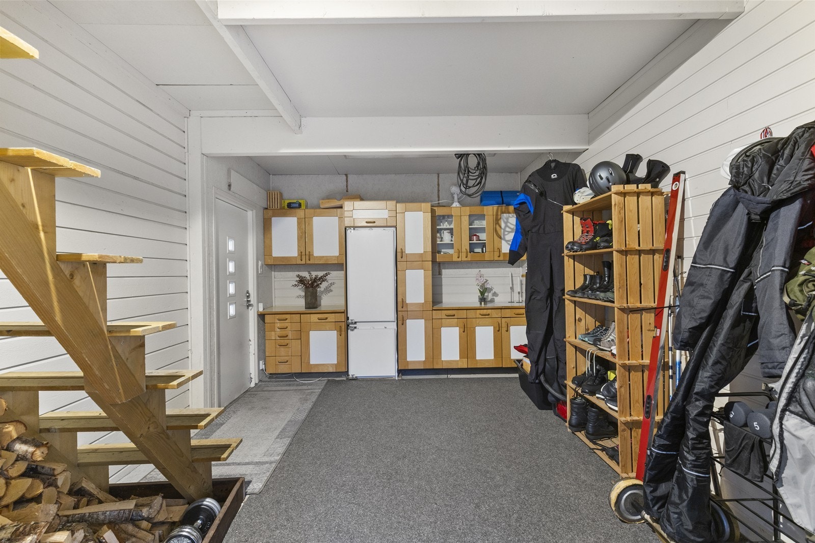 Utebod mellom bolig og garasje med trapp til lagringsloft, samt dør ut til veranda. Galleribilde