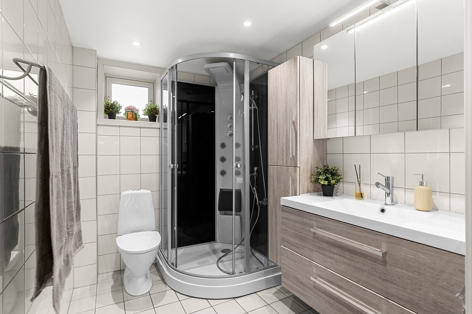 Lyst og lekkert bad i 2. etasje med flislagt gulv og vegger. Det er varmekabler i gulvet på begge baderommene. Galleribilde