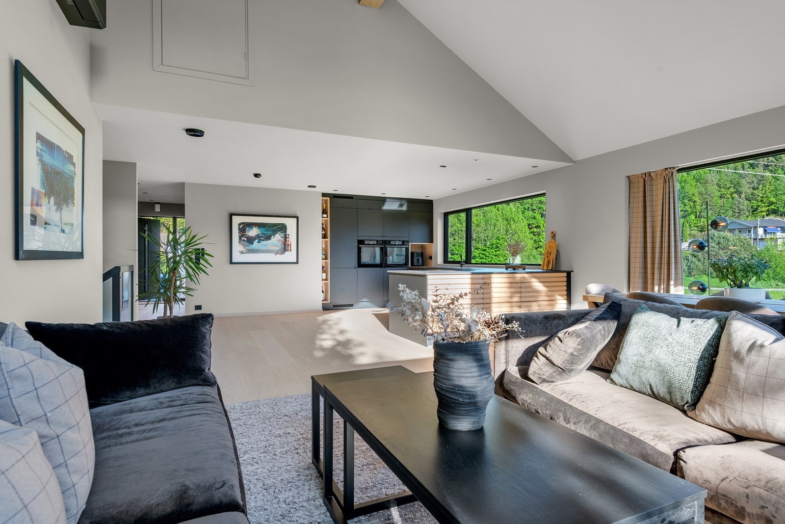 Moderne stue med store vinduer som gir rikelig med naturlig lys og vakker utsikt til frodig natur utenfor..jpg Galleribilde