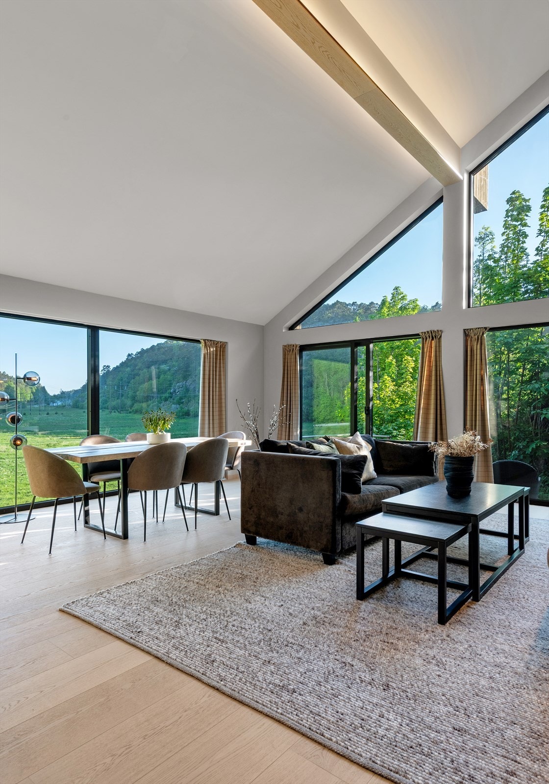 Moderne stue med store vinduer, rikelig naturlig lys og vakker utsikt over frodig landskap. Perfekt for avslapning og underholdning..jpg Galleribilde