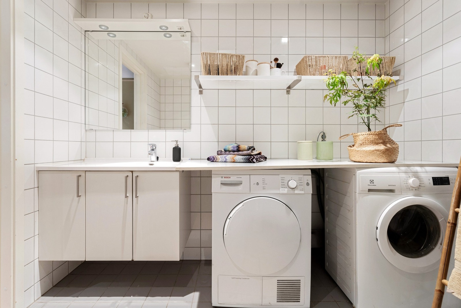 Badet har flislagte vegger, gulv med gulvvarme og opplegg for vaskemaskin og tørketrommel. Galleribilde