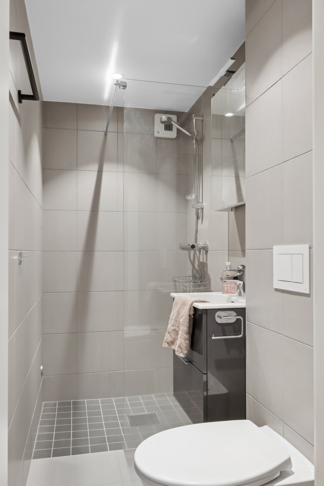 Baderom 2 ligger i tilknytning til entré, og er innredet med nedfelt servant, veggmontert toalett og dusjvegger/hjørne. Galleribilde