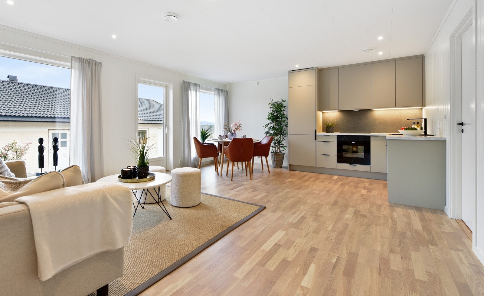 Lyst og moderne oppholdsrom med åpen stue- og kjøkkenløsning Galleribilde