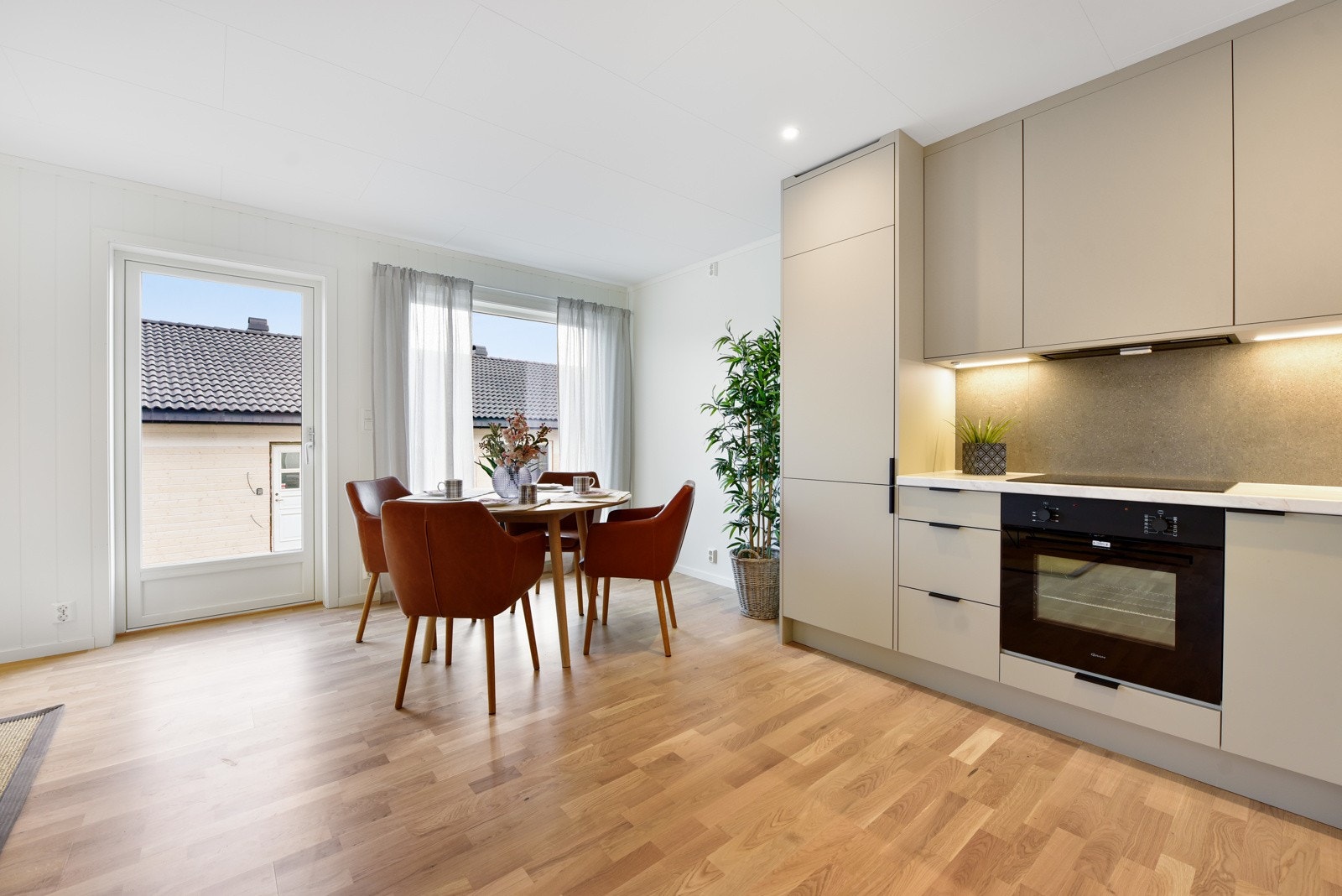 Det stilrene kjøkkenet har integrert komfyr, platetopp og oppvaskmaskin Galleribilde