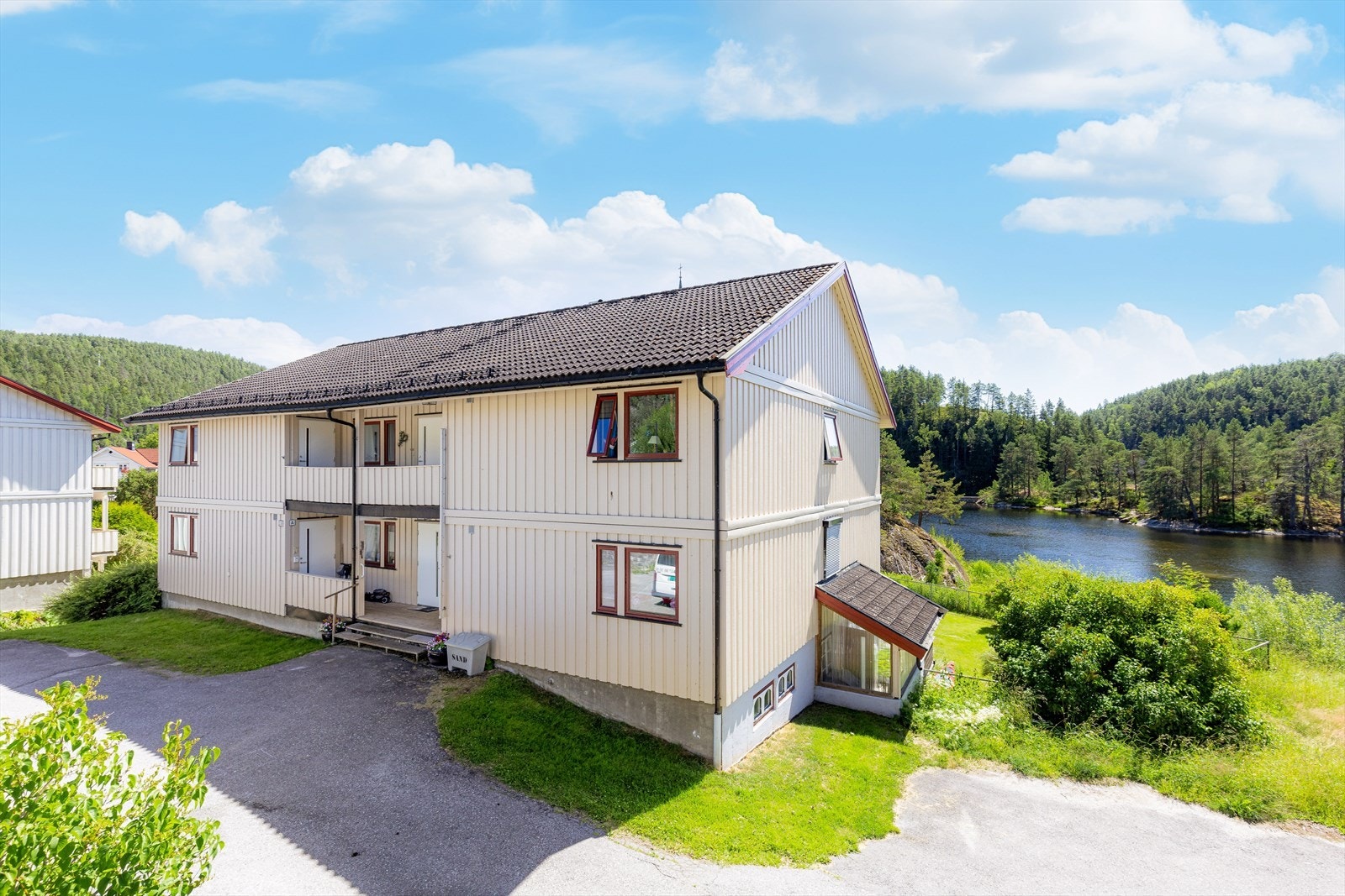 Sameiets tomt er pent opparbeidet med gressplen, busker og trær. Det er også noe tjuahekk. Asfalterte internveier og biloppstillingsplass. Galleribilde