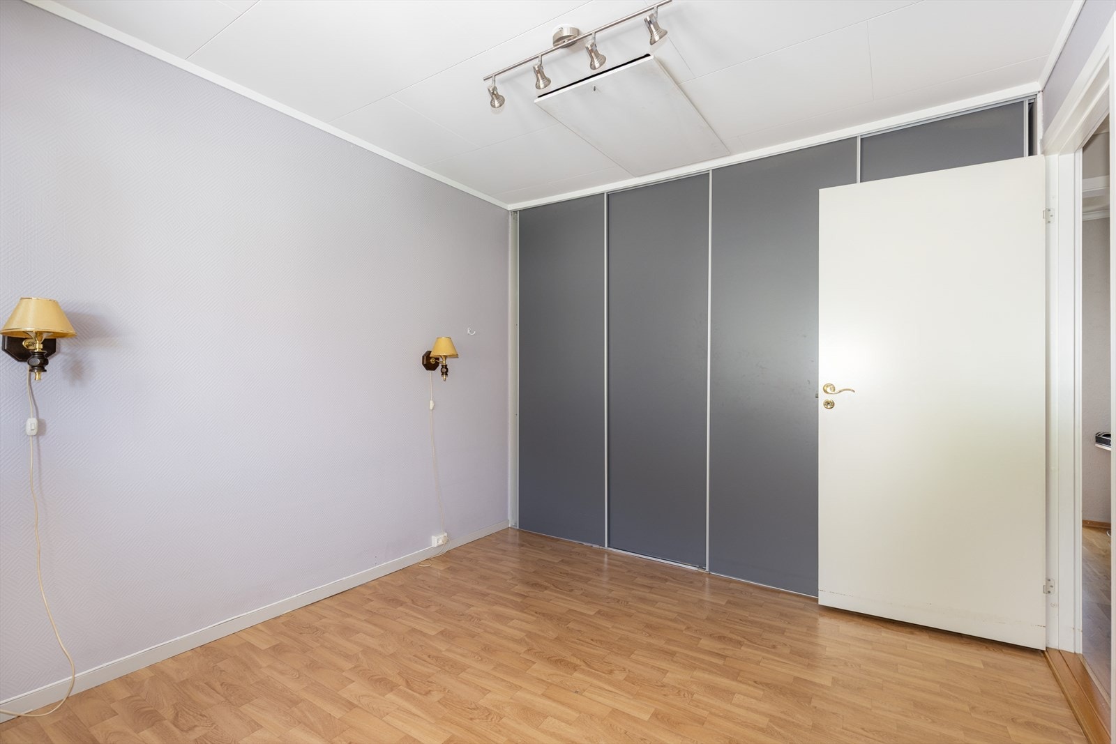 Langs den ene veggen er det etablert en stor og praktisk skyvedørsgarderobe for klesoppbevaring. Galleribilde